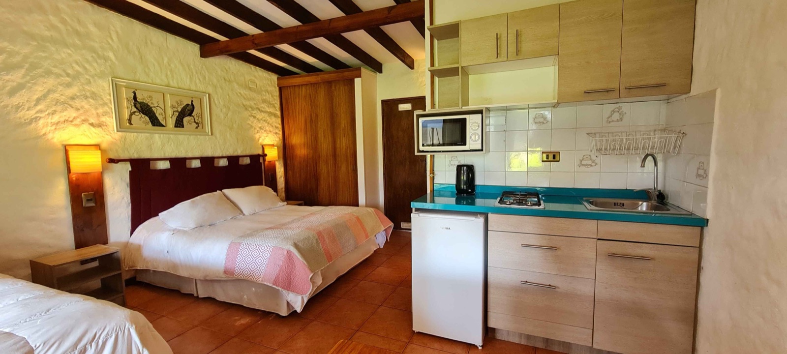 Departamento de un ambiente con cama matrimonial y kitchenette